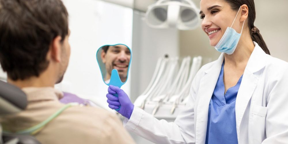 Positive,Man,Checking,Results,Of,Teeth,Whitening,Treatment,In,The dentist auburn